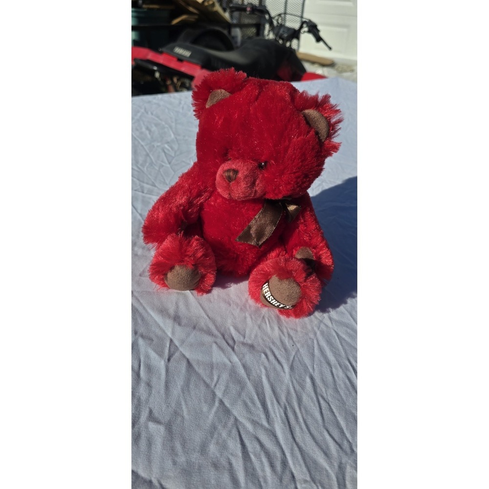 red Hershey's brand plush teddy bear with a brown bow and branded foot detail